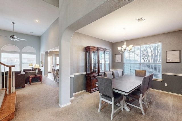 dining area with light colored carpet and ceiling fan with notable chandelier