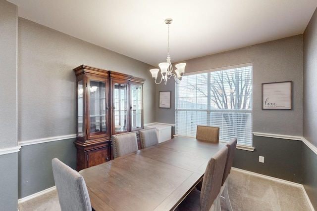 carpeted dining space featuring an inviting chandelier