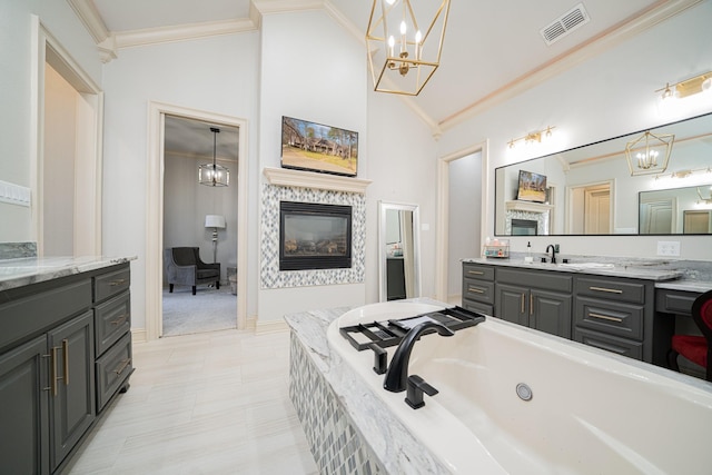 bathroom featuring crown molding, vanity, tiled bath, and a notable chandelier