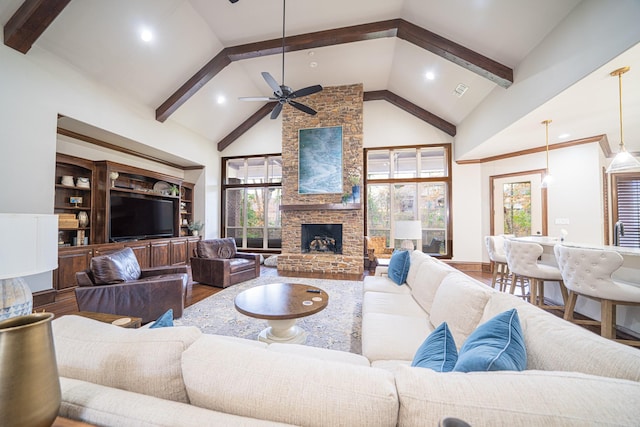 living room featuring beamed ceiling, high vaulted ceiling, hardwood / wood-style floors, and a fireplace