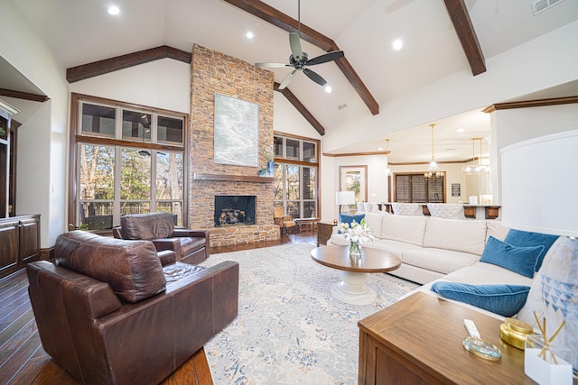 living room featuring a stone fireplace, wood-type flooring, high vaulted ceiling, and beamed ceiling