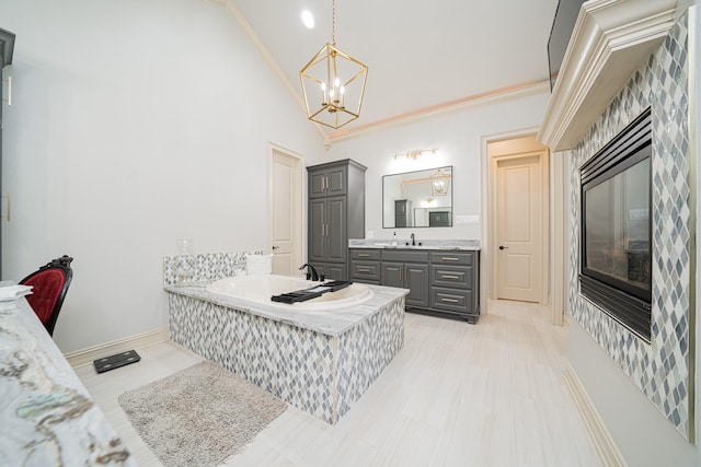 bathroom with crown molding, high vaulted ceiling, vanity, a notable chandelier, and a bathing tub