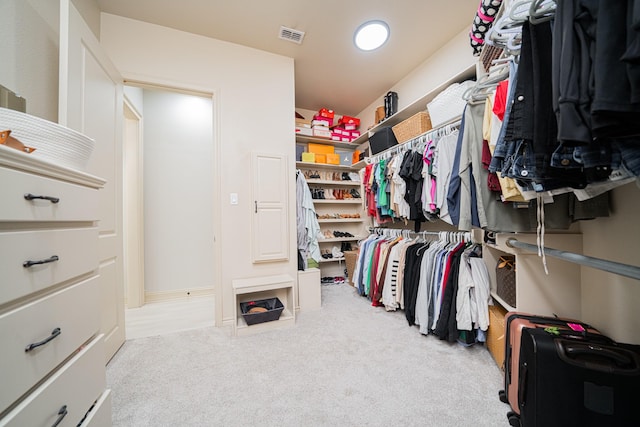 walk in closet featuring light carpet