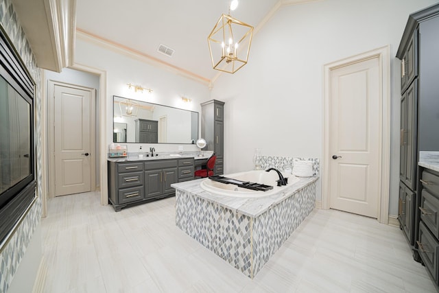 bathroom featuring lofted ceiling, crown molding, a relaxing tiled tub, a notable chandelier, and vanity