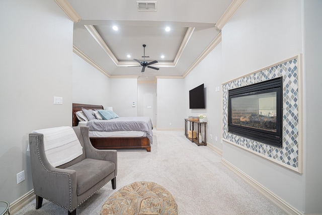 bedroom with a tray ceiling, ornamental molding, ceiling fan, and carpet