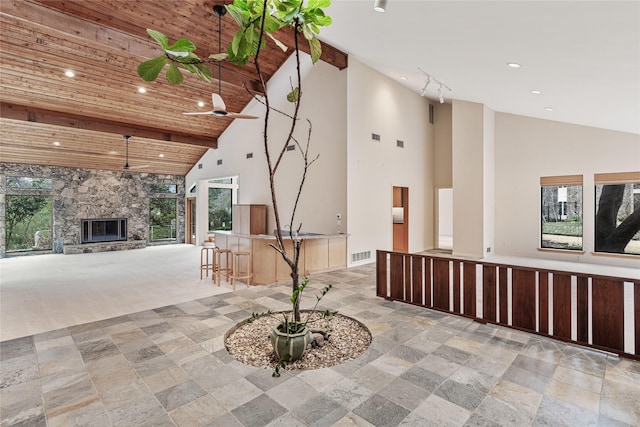 interior space featuring light colored carpet, wooden ceiling, and high vaulted ceiling