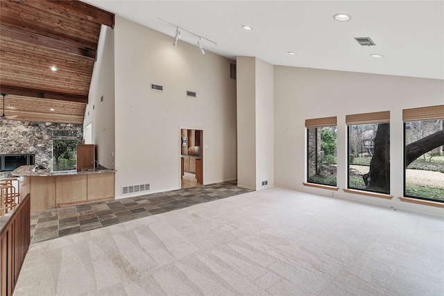 unfurnished living room featuring high vaulted ceiling, dark carpet, and a fireplace