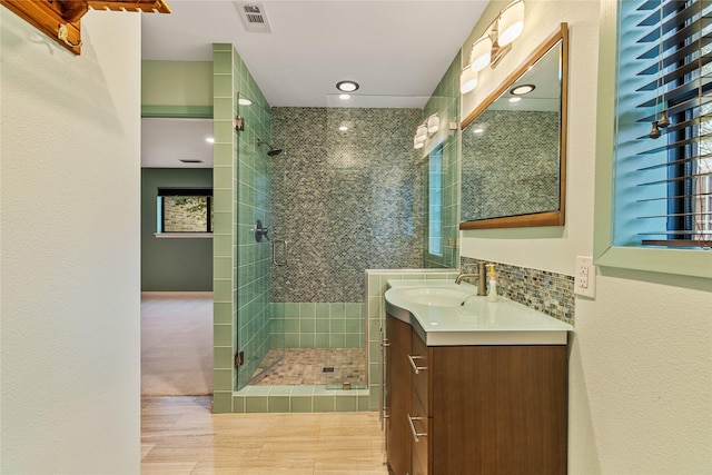 bathroom with hardwood / wood-style flooring, vanity, and an enclosed shower