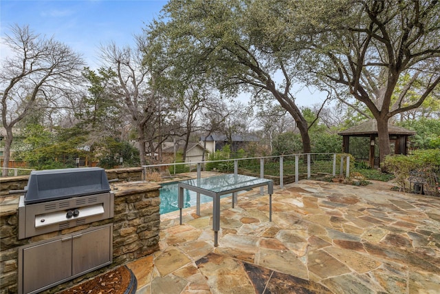 view of patio / terrace with a gazebo, an outdoor kitchen, a fenced in pool, and area for grilling