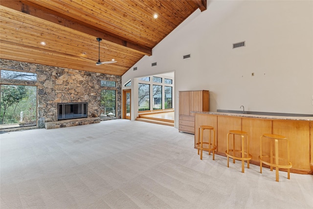 unfurnished living room featuring a healthy amount of sunlight, wooden ceiling, and beamed ceiling