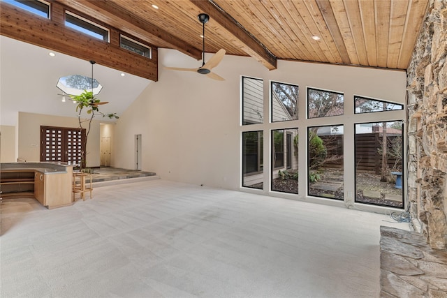 unfurnished living room featuring high vaulted ceiling, light colored carpet, and wood ceiling