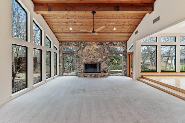 unfurnished sunroom featuring a fireplace, wooden ceiling, lofted ceiling with beams, and plenty of natural light