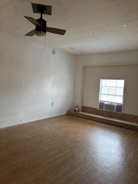 unfurnished room featuring cooling unit, hardwood / wood-style flooring, and ceiling fan