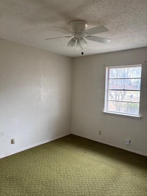 empty room with ceiling fan, carpet flooring, and a textured ceiling