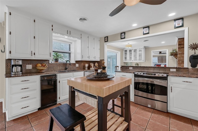 kitchen with sink, stainless steel electric range, white cabinets, ceiling fan, and backsplash