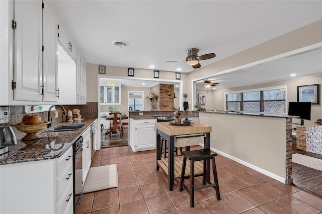 kitchen featuring white cabinetry, sink, plenty of natural light, and kitchen peninsula