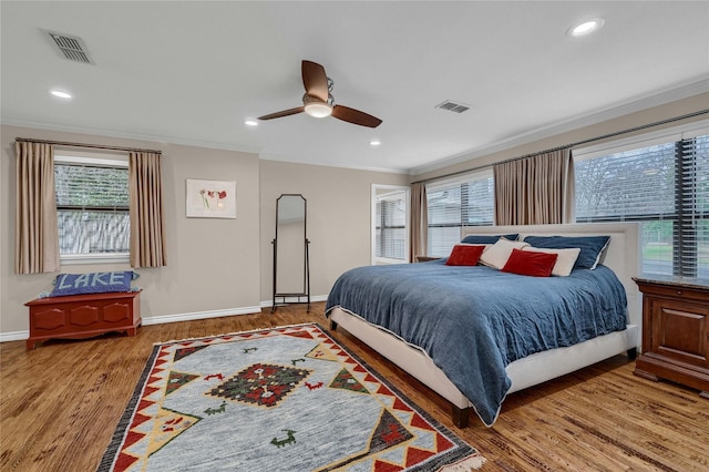 bedroom featuring hardwood / wood-style flooring, ornamental molding, and ceiling fan