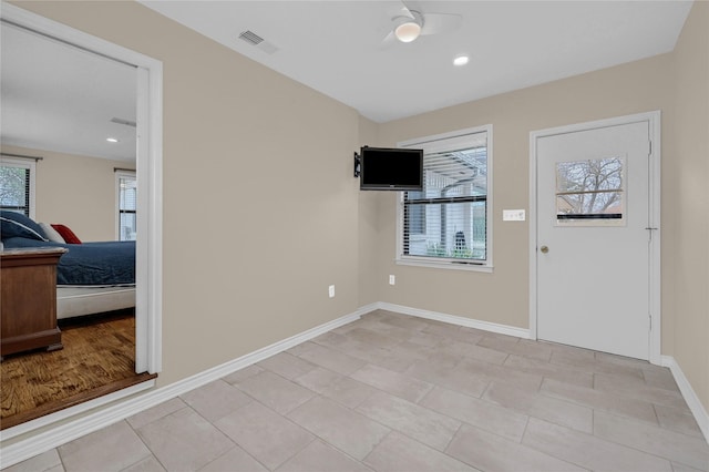 entryway with ceiling fan, light tile patterned floors, and a wealth of natural light