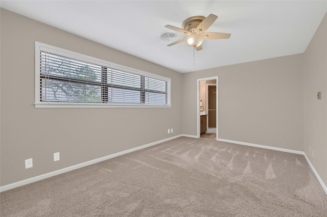 carpeted spare room featuring ceiling fan