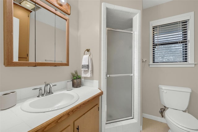 bathroom featuring vanity, toilet, and a shower with door