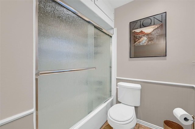 bathroom featuring bath / shower combo with glass door and toilet