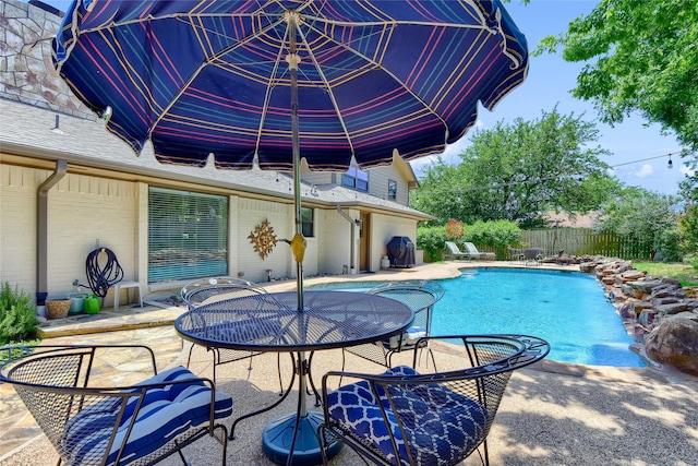 view of swimming pool featuring grilling area and a patio