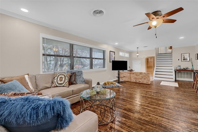 living room with crown molding, dark wood-type flooring, and ceiling fan