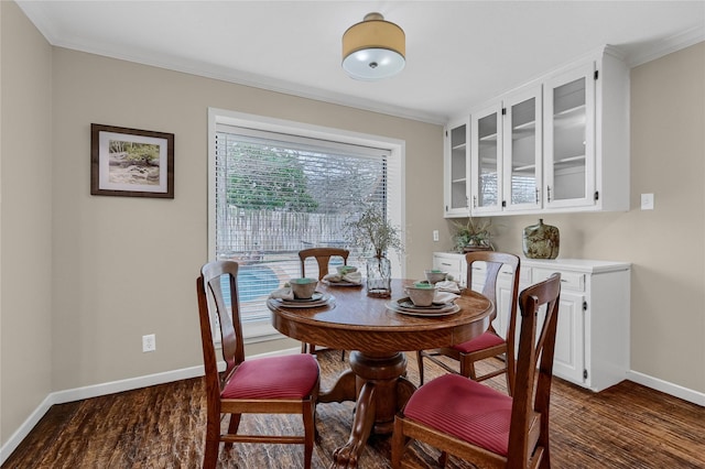 dining space with ornamental molding and dark hardwood / wood-style floors