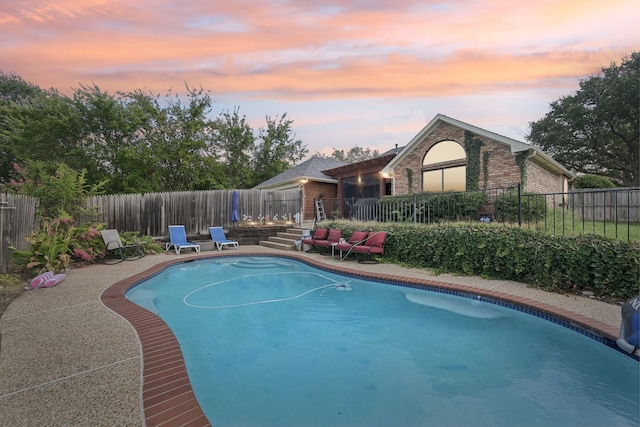 view of pool at dusk