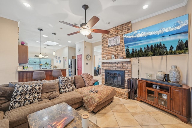 tiled living room with crown molding, ceiling fan, and a fireplace