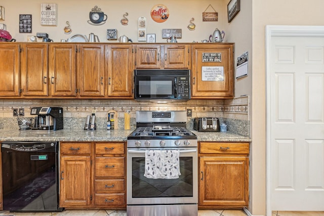 kitchen with light stone countertops, decorative backsplash, black appliances, and light tile patterned flooring