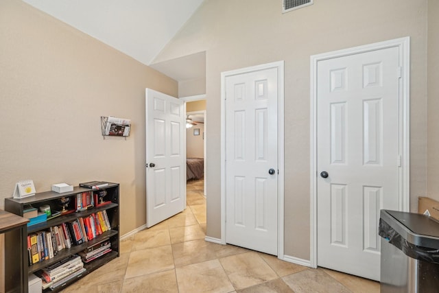 interior space with lofted ceiling and light tile patterned floors