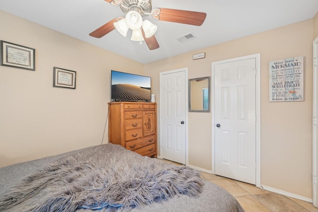 tiled bedroom featuring ceiling fan