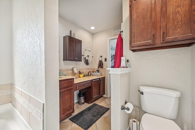 bathroom with vanity, a tub to relax in, tile patterned floors, and toilet