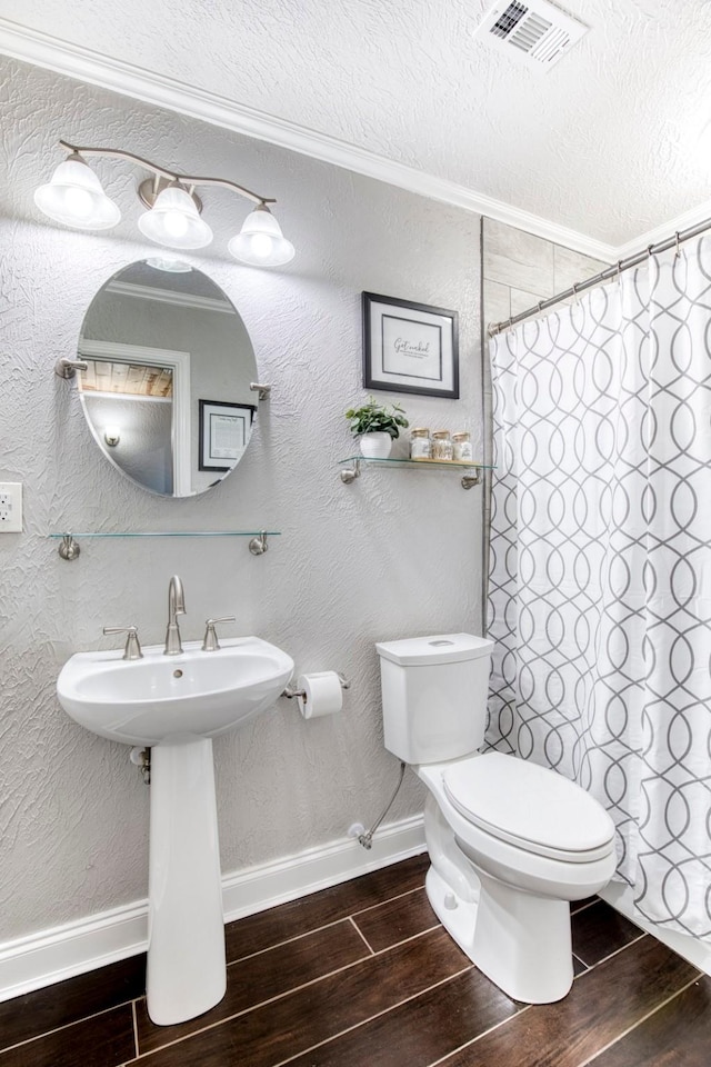 bathroom featuring a shower with curtain, crown molding, a textured ceiling, and toilet