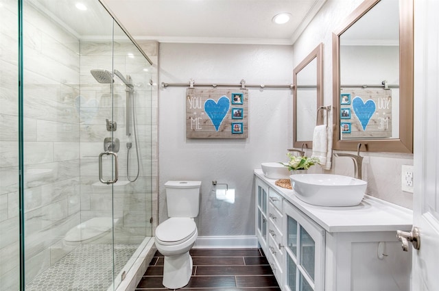 bathroom featuring ornamental molding, toilet, an enclosed shower, and vanity