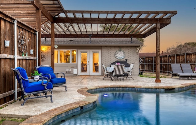 pool at dusk with a pergola, a patio area, and french doors