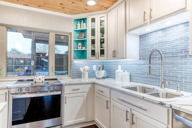 kitchen with sink, white cabinetry, light stone counters, stainless steel appliances, and decorative backsplash