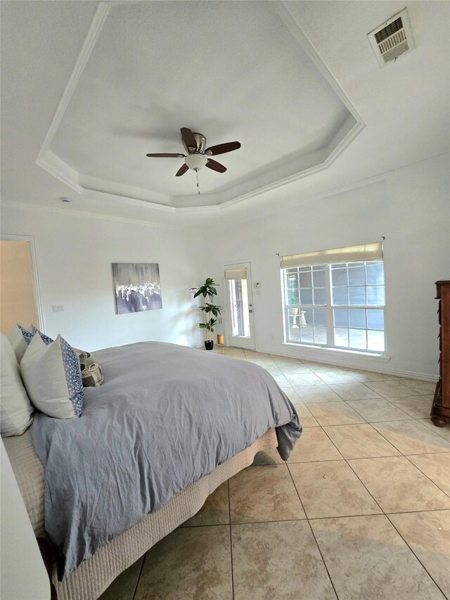 tiled bedroom featuring ceiling fan and a tray ceiling