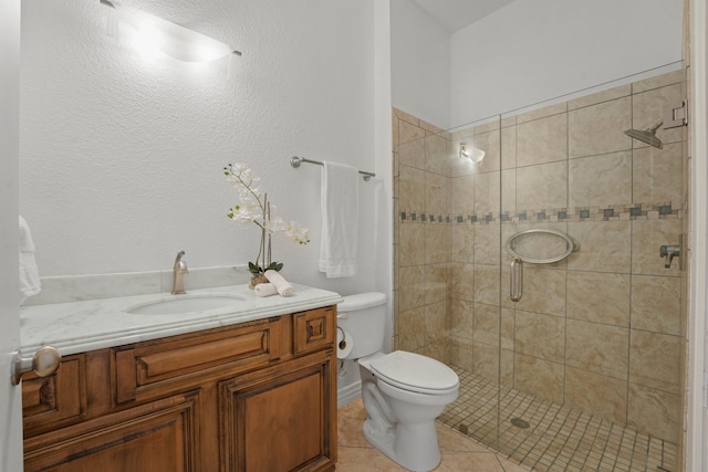 bathroom with tile patterned flooring, vanity, a shower with shower door, and toilet