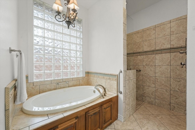 bathroom with tile patterned floors, shower with separate bathtub, and a chandelier