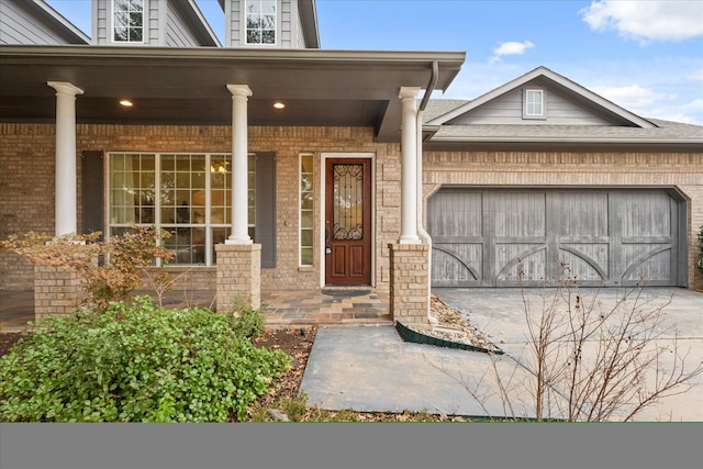 doorway to property with a garage and a porch