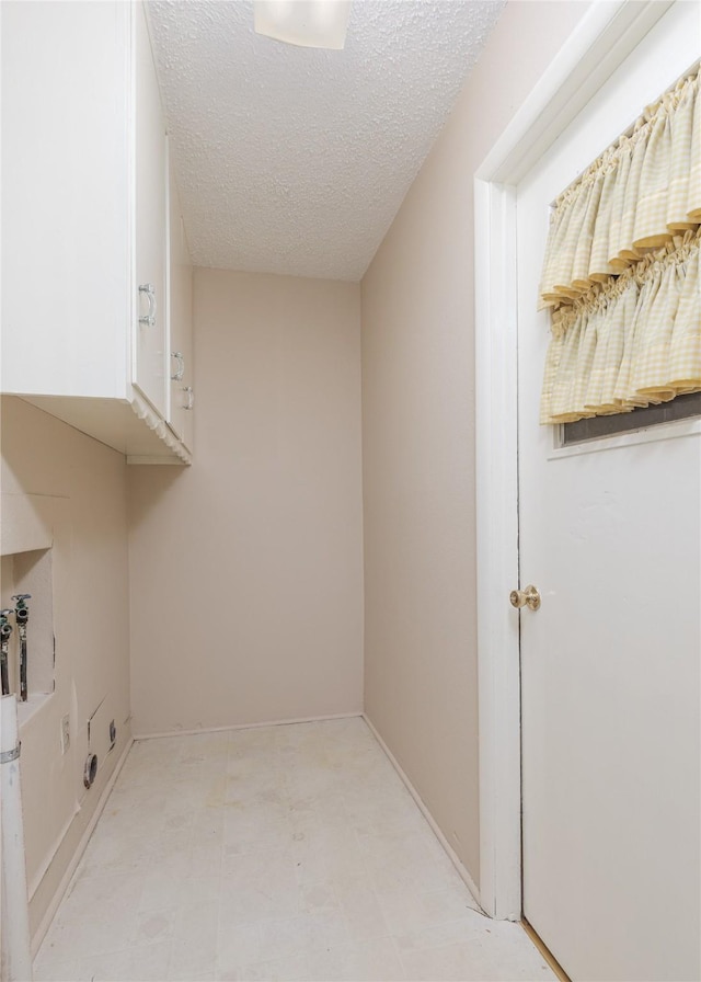 clothes washing area with a textured ceiling