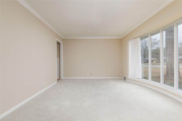 carpeted spare room with ornamental molding and a textured ceiling