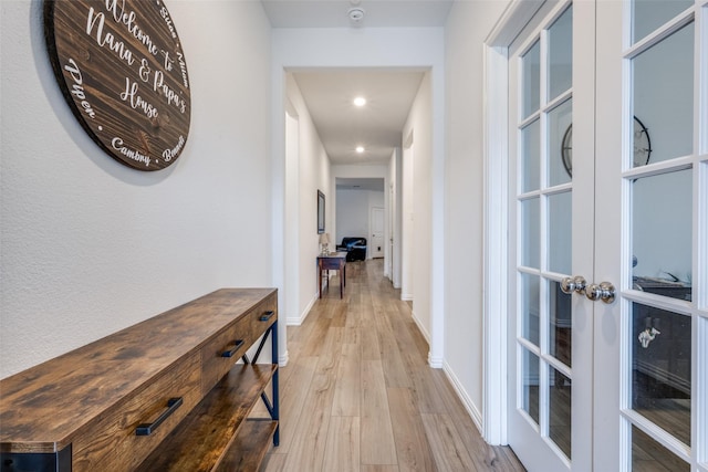 hallway featuring light wood-type flooring, french doors, baseboards, and recessed lighting