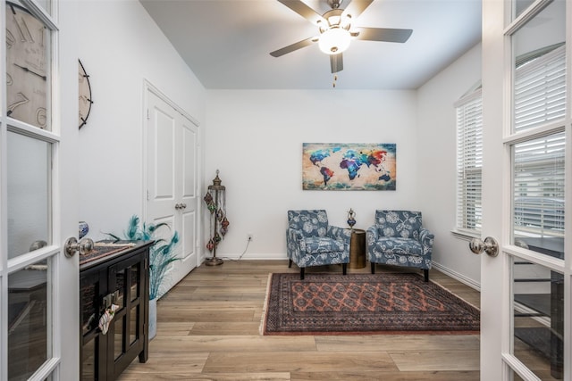 sitting room with french doors, ceiling fan, and light hardwood / wood-style floors