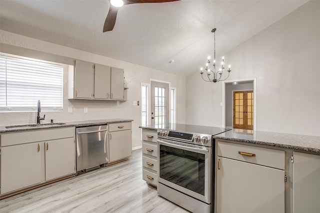 kitchen featuring sink, vaulted ceiling, light hardwood / wood-style flooring, appliances with stainless steel finishes, and pendant lighting