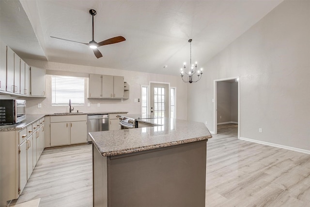 kitchen featuring sink, stainless steel appliances, hanging light fixtures, and a kitchen island