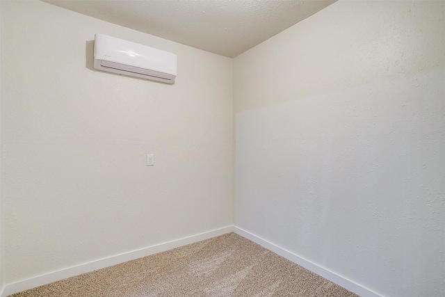 unfurnished room featuring a textured ceiling, a wall mounted AC, and carpet