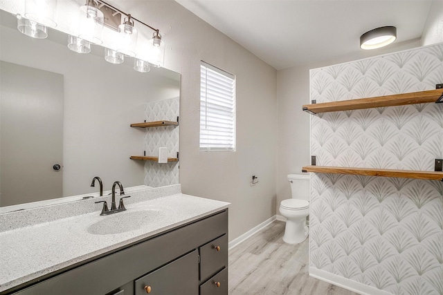 bathroom featuring wood-type flooring, vanity, and toilet